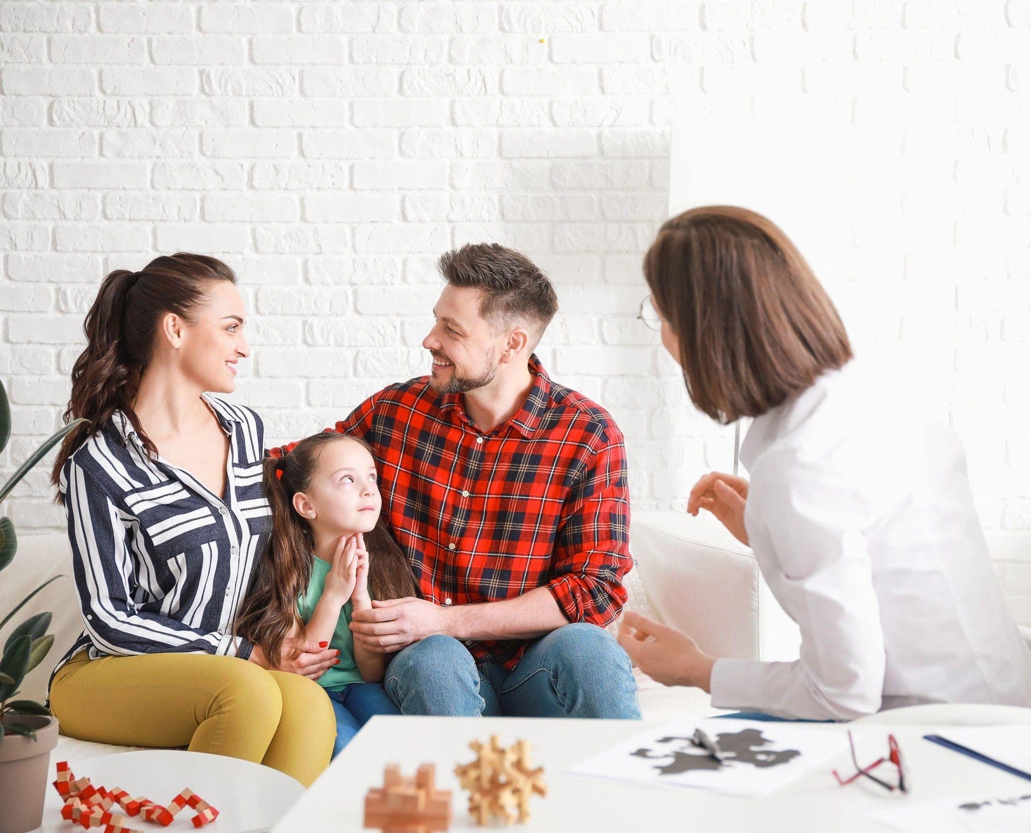 Building a Better Connection Takes Time with Counselor sitting with parents and child in a comfortable, bright counseling room.