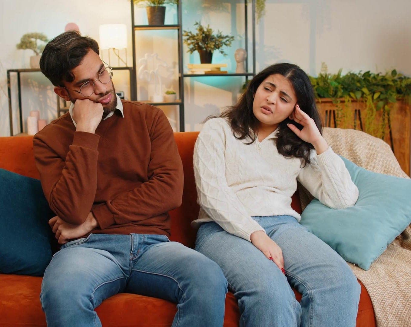 A couple sitting together but struggling to communicate, with subtle serious expressions rather than dramatic anger. Couples Marriage Counseling for Better Understanding